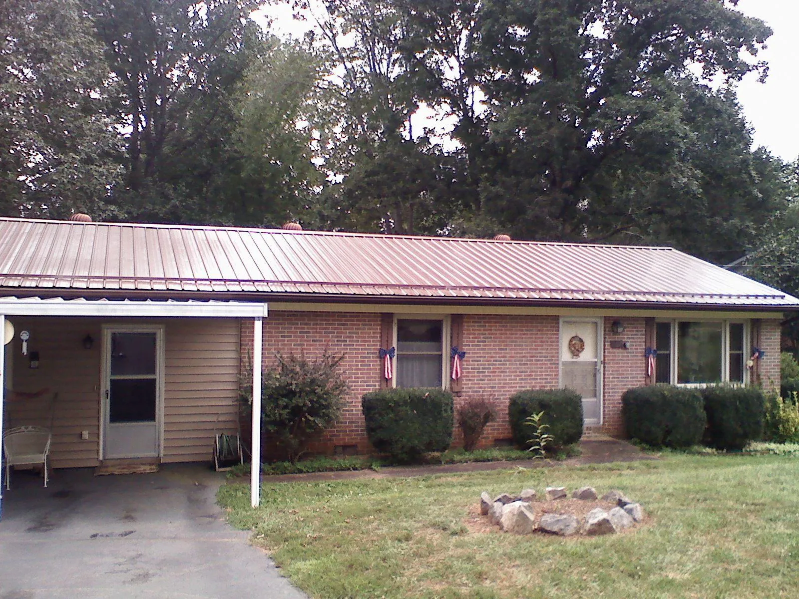 Bronze metal roof and carport on a brick ranch home — Roof Repair work by our crew in Maple Hill