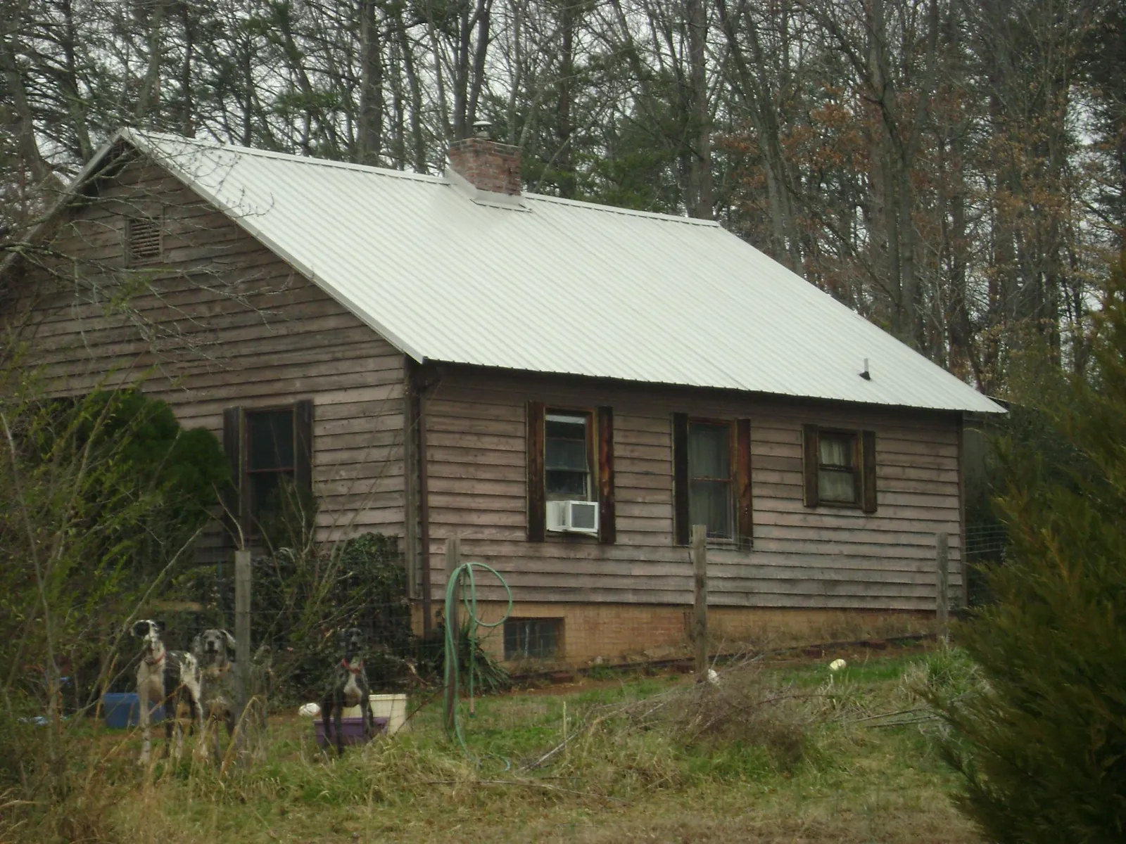 White metal roof on an old wood sided farmhouse, from a Metal Roof Installation job in Maple Hill